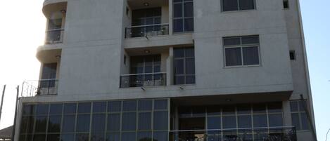Un immeuble à plusieurs étages doté de balcons et de grandes fenêtres.
