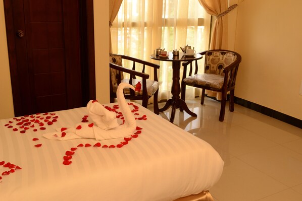 A hotel room with a bed, a dining table with chairs, and a door. - Lake Mark Hotel (Bahir Dar)