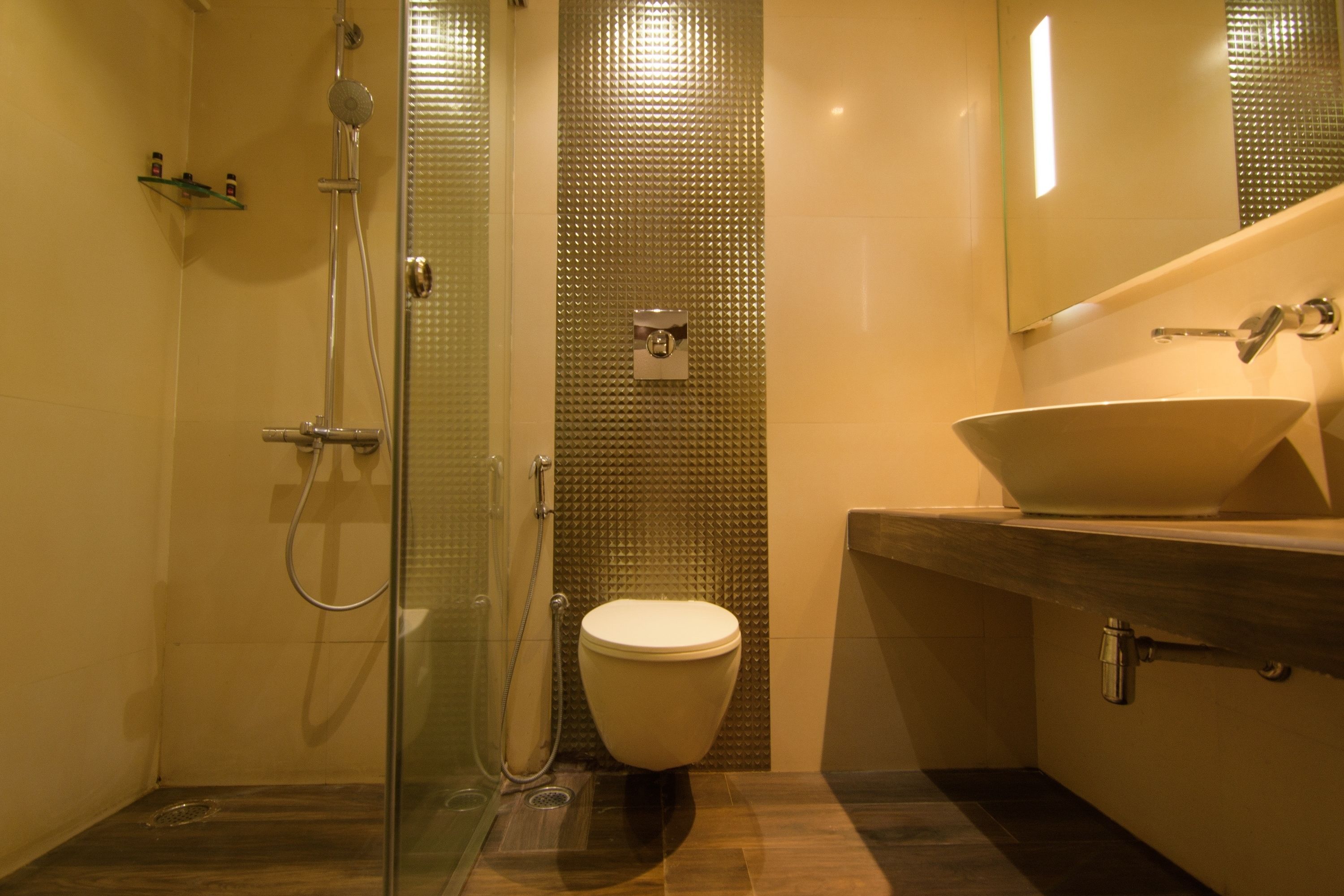 Une salle de bain moderne dotée d’une douche à parois de verre, de toilettes et d’un meuble-lavabo avec un grand évier.