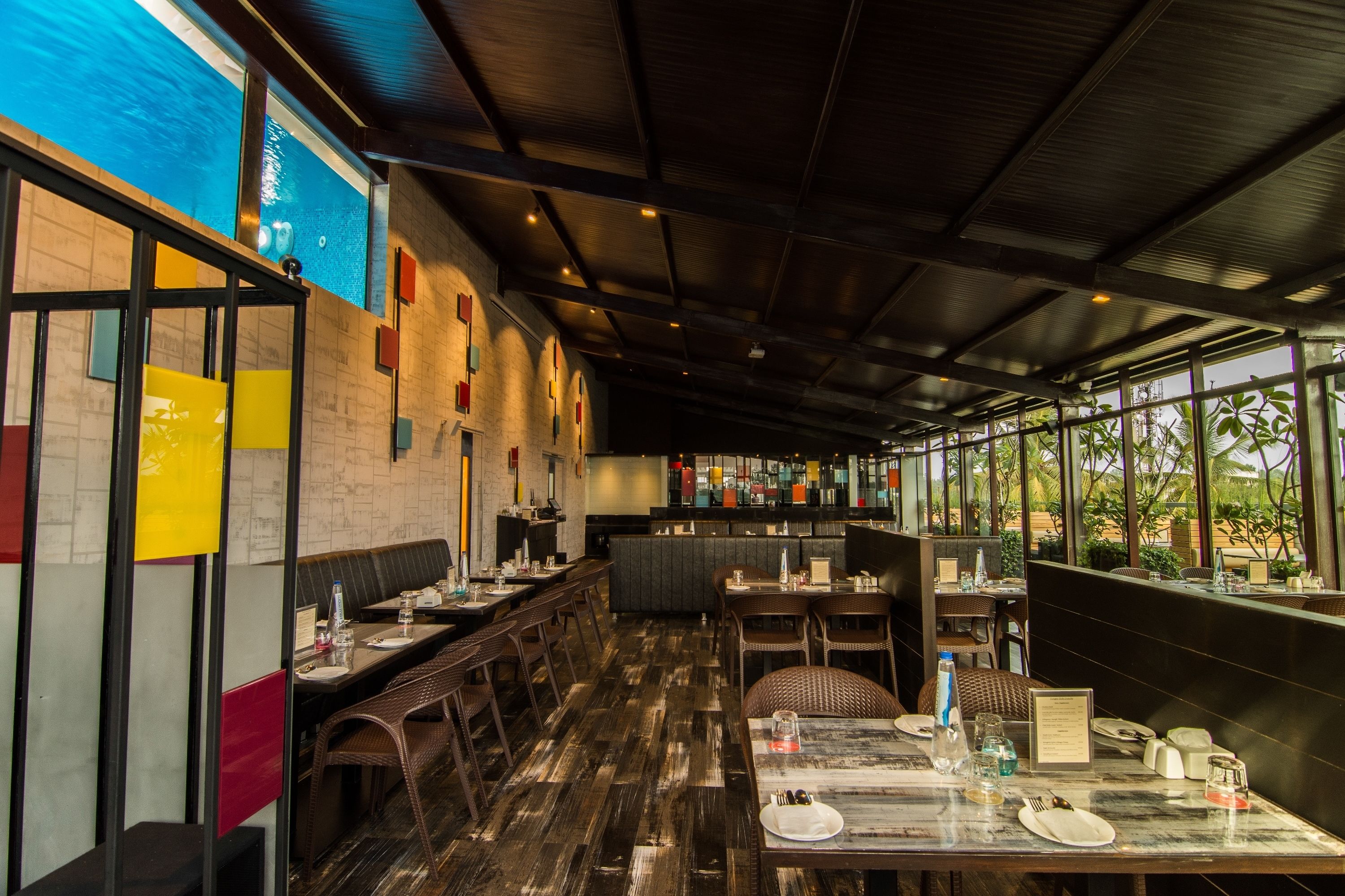 A restaurant with a long counter, booths, and a bar area.