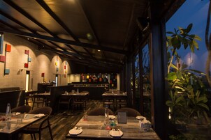 Un restaurante con mesas altas, sillas y una zona de bar.