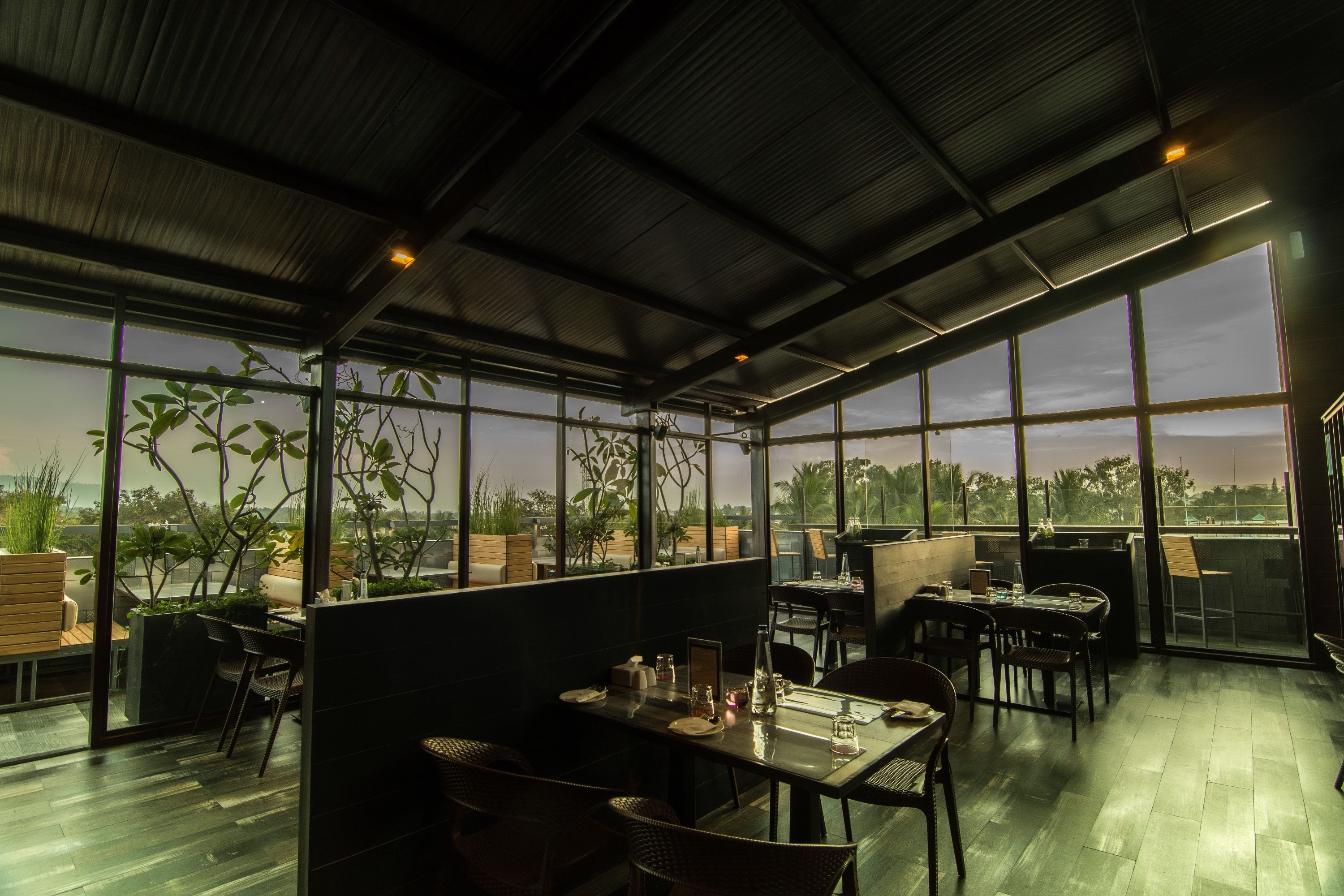 A spacious indoor dining area with high ceilings and large windows offering views of the outdoors.