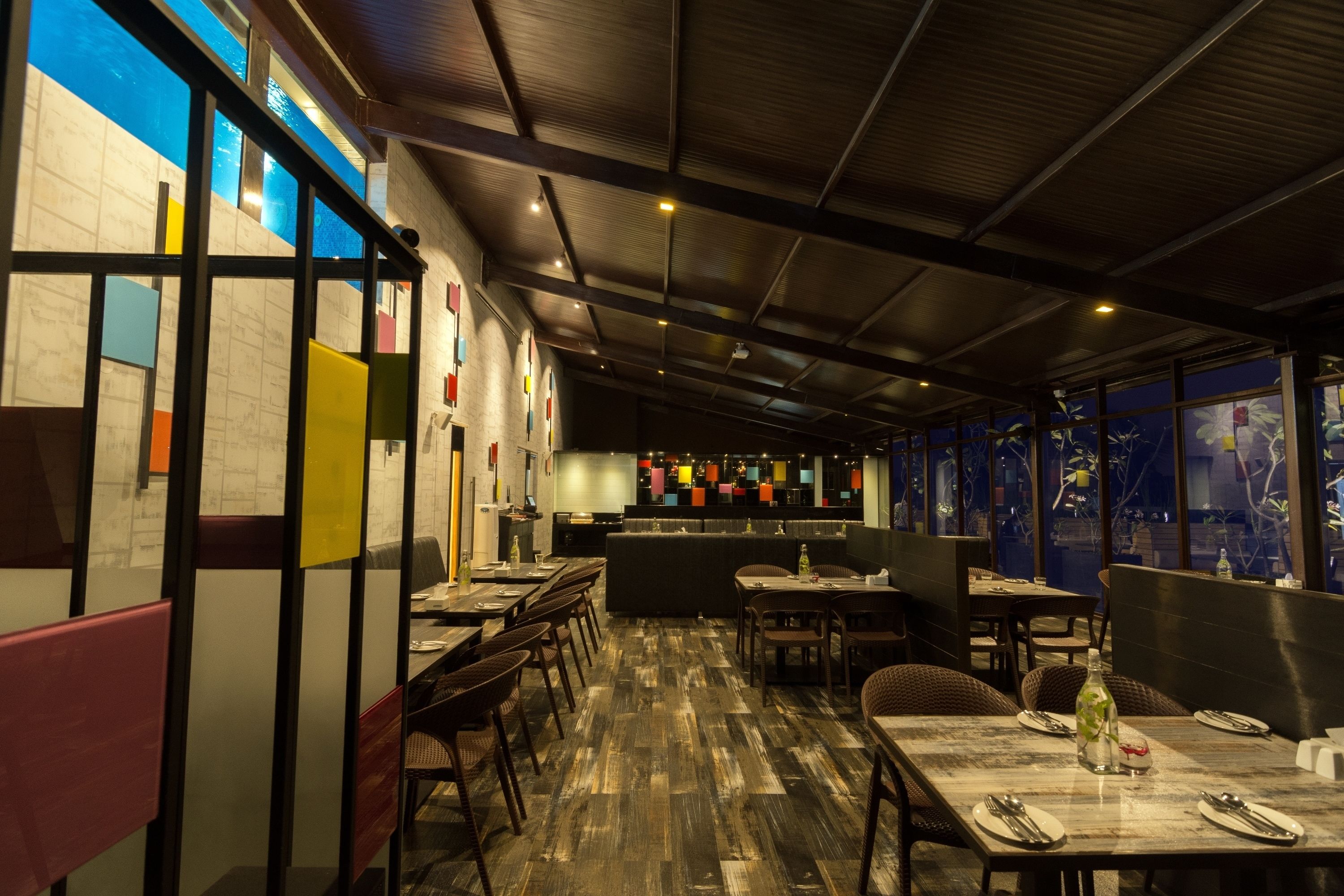 Ein Restaurant mit hohen Decken, freiliegenden Balken und verschiedenen Sitzgelegenheiten, darunter Sitzecken und Tische.