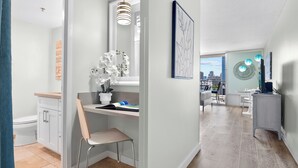 A modern kitchen with a white countertop, a chair, and a potted orchid.