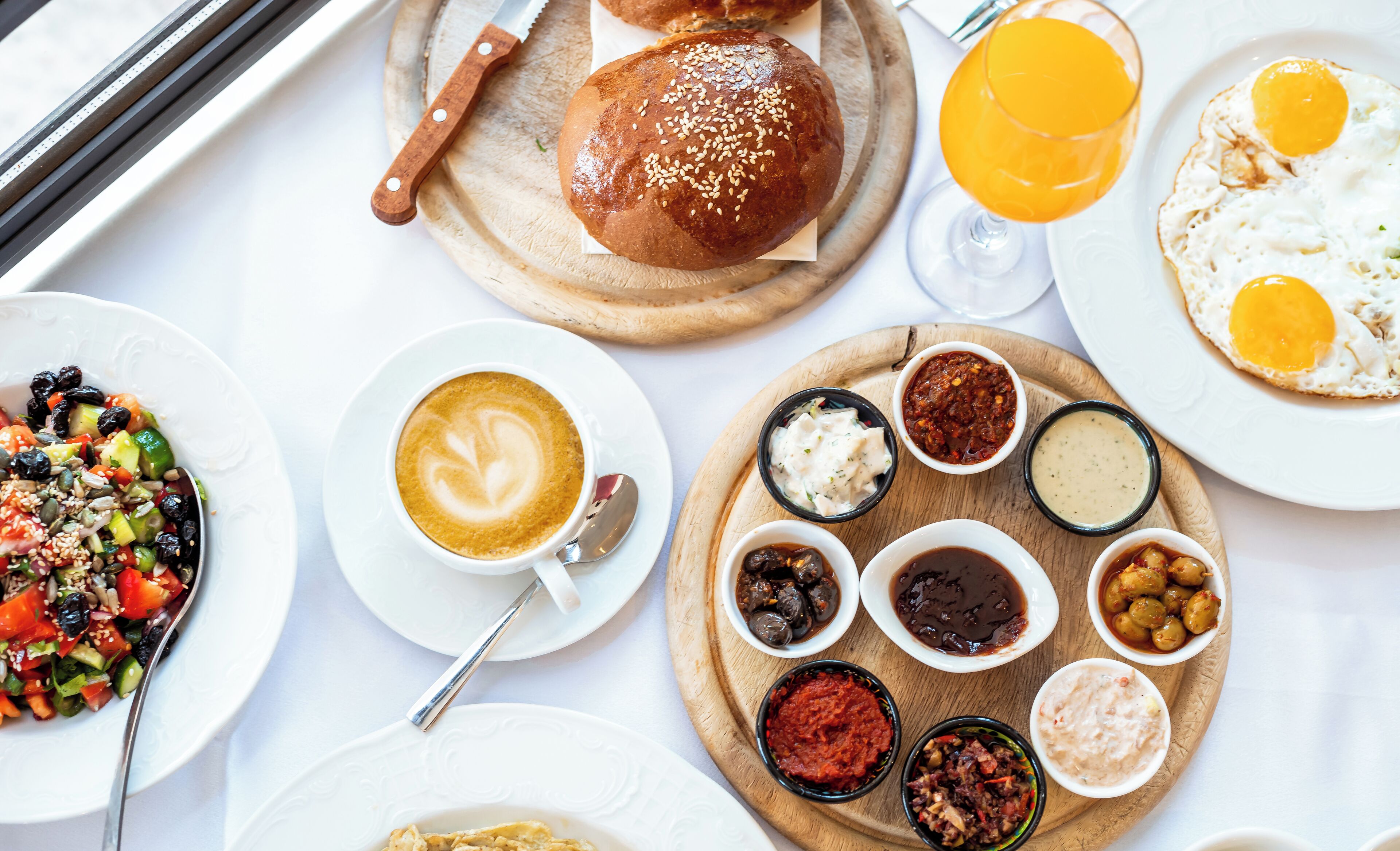 Una bandeja de desayuno con pan, huevos, una taza de café y diferentes acompañamientos.