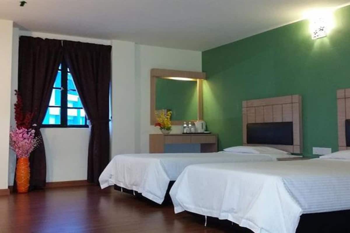 Habitación de hotel con dos camas, un escritorio pequeño, un espejo y un ventanal con cortinas.