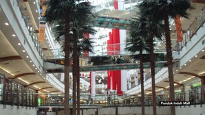 A multi-level shopping mall with glass railings and palm trees. - ZEN Rooms Setiabudi 15 (Jakarta)