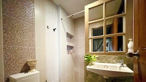 A bathroom with a toilet, shower, sink, and a mirror with a window. - Winnine Cozy Home (Bangkok)