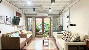 A living room with two sofas, a coffee table, and a television. - Winnine Cozy Home (Bangkok)