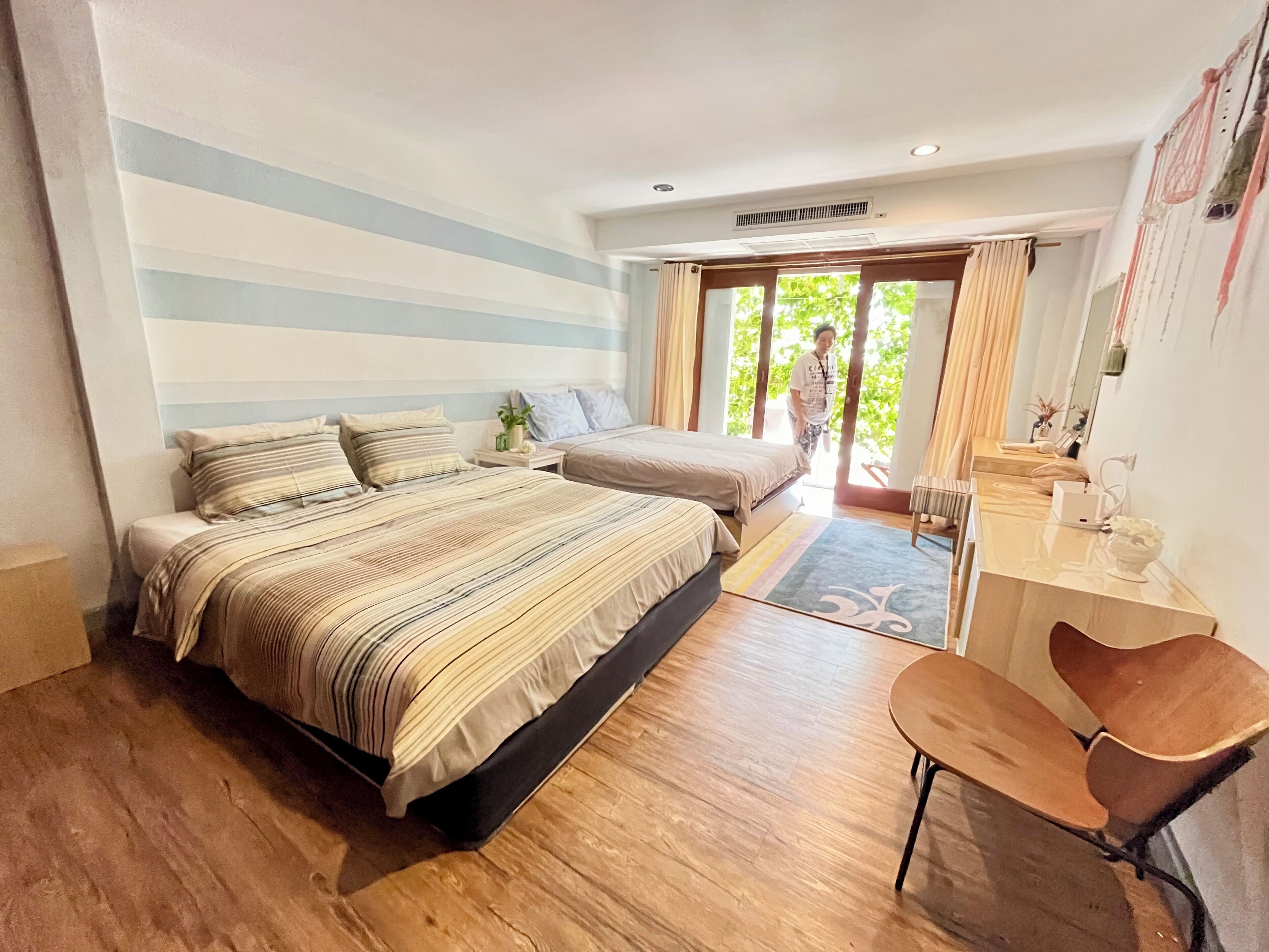 A bedroom with two beds, a desk, and a chair.