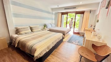 A bedroom with two beds, a desk, and a chair.