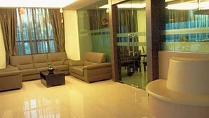 A modern living room with a sofa set, a coffee table, and a glass partition. - Sutera Hotel (Seremban)