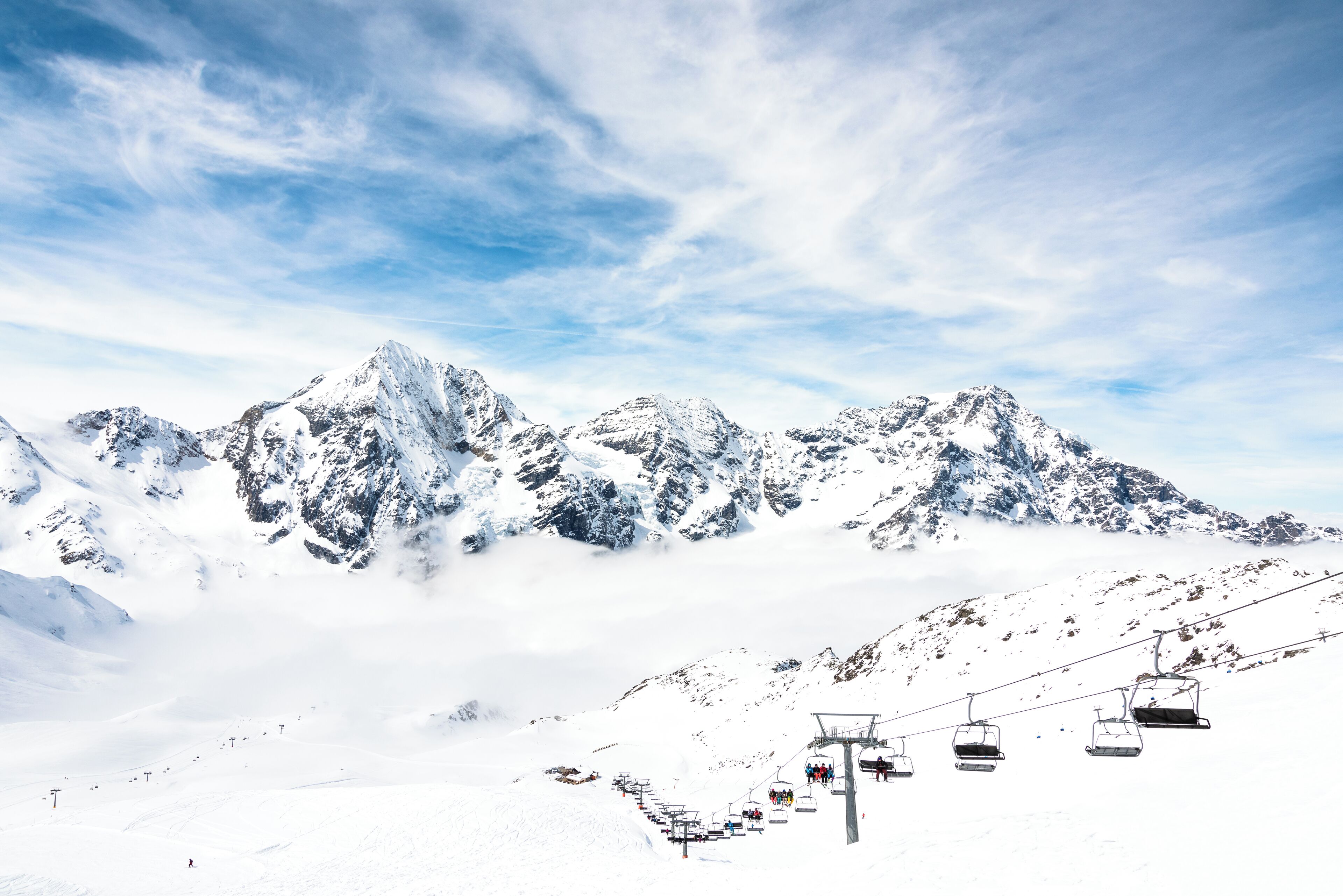 A snow-covered mountain with a ski lift and a clear sky.