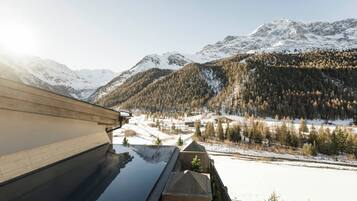 Una piscina techada, una piscina al aire libre, sombrillas