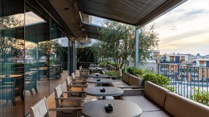 Terraza en la azotea con asientos exteriores y vistas a la ciudad.