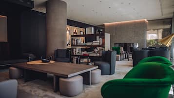 A modern living room with a large bookshelf, a fireplace, and a green armchair.