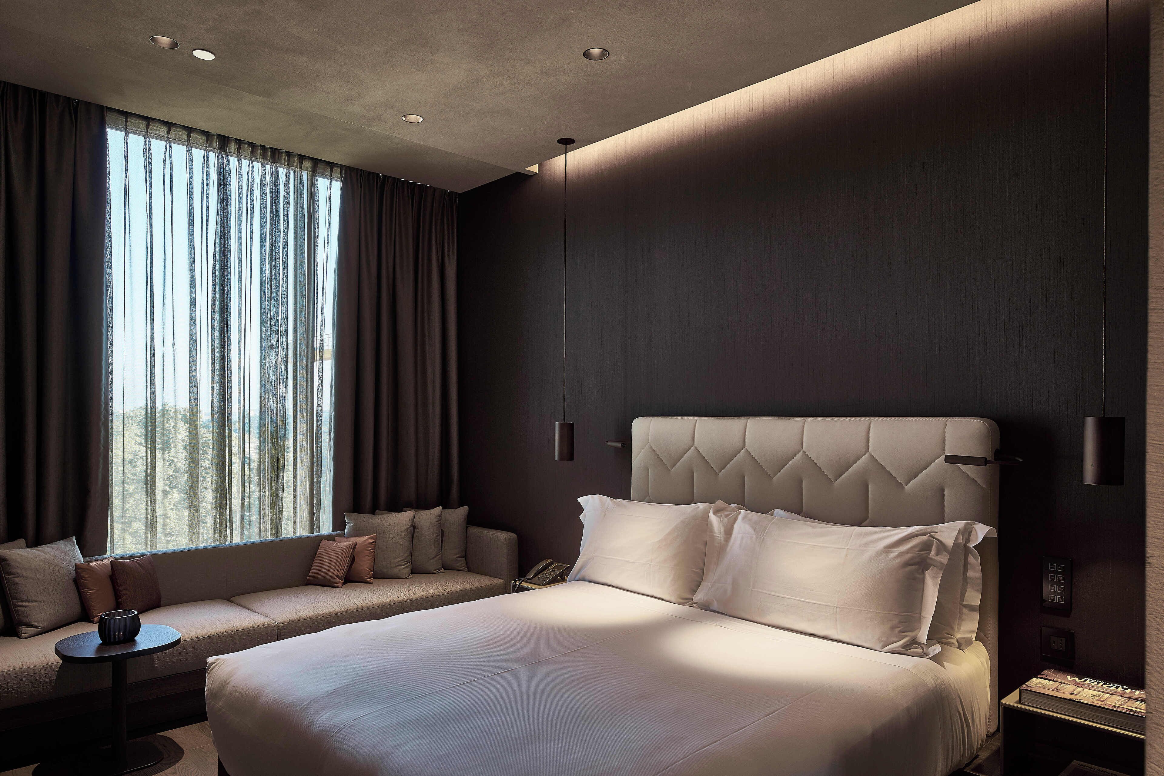 Ein modernes Hotelzimmer mit einem großen Bett, einer Couch und einem kleinen Tisch.