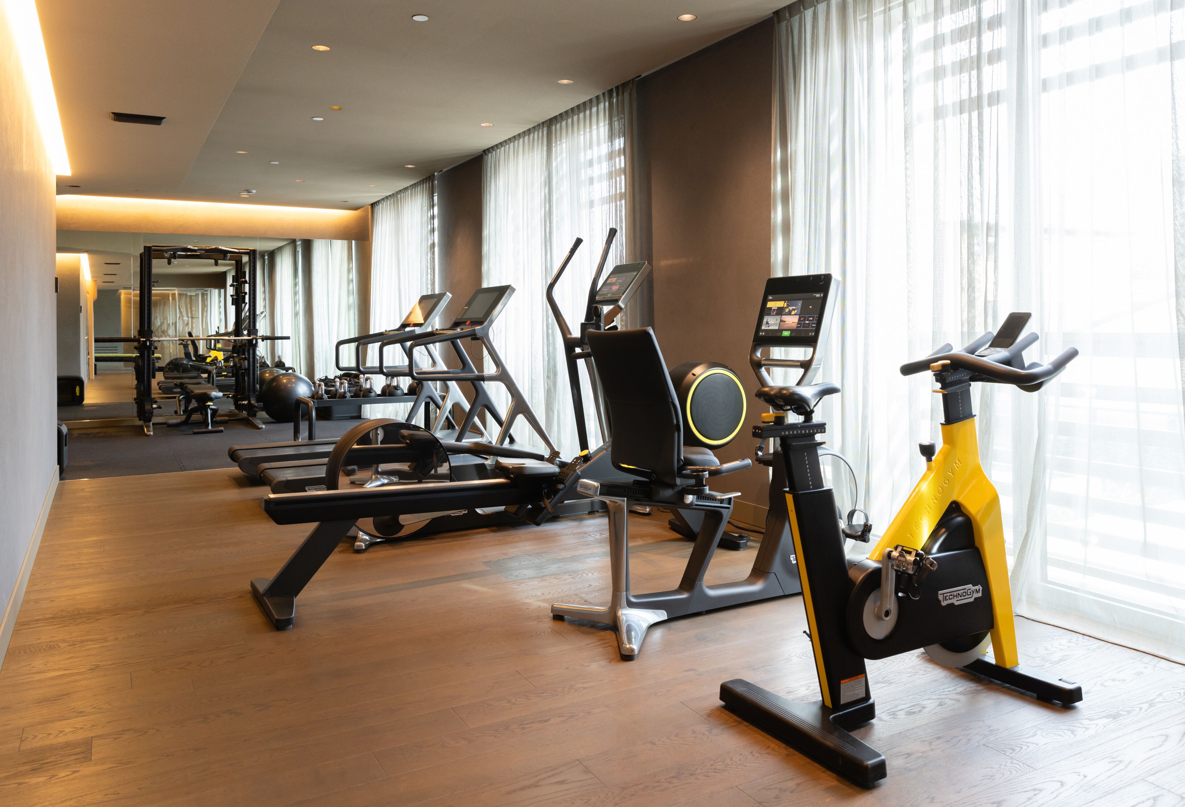 Ein Fitnessraum mit Laufbändern, Crosstrainern und einem Ergometer.