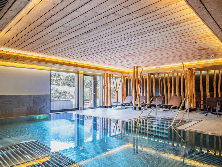 Una piscina con vigas de madera y una vista despejada del exterior.