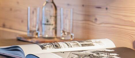 A wooden table with a magazine and a bottle of water.