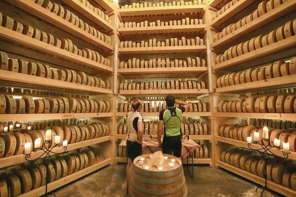A large wine cellar with wooden shelves filled with wine barrels.