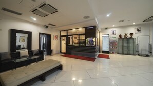 A modern lobby with a reception desk, seating area, and a vending machine. - Astory Hotel (Plzen)