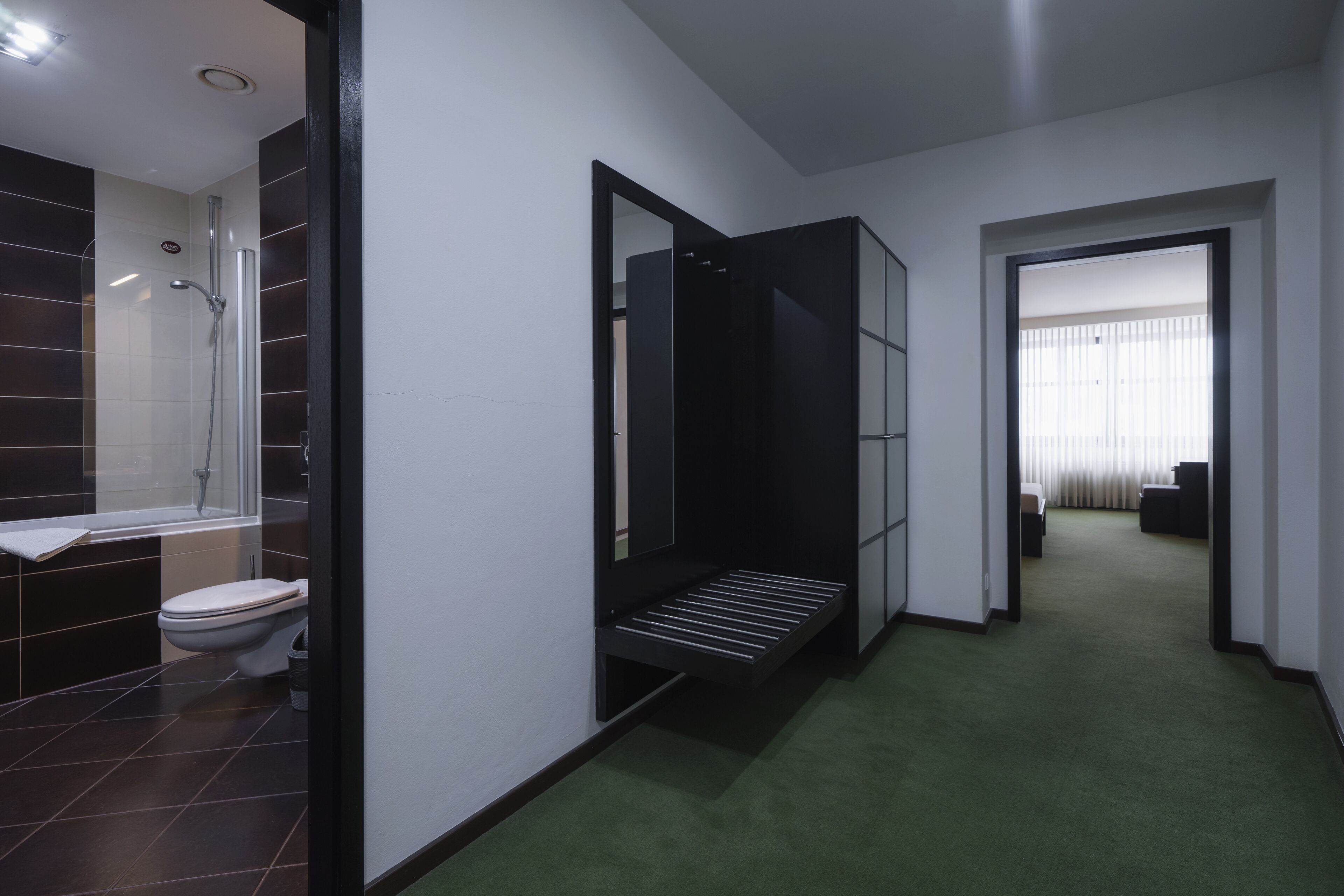 Un baño moderno con ducha, inodoro y espejo.