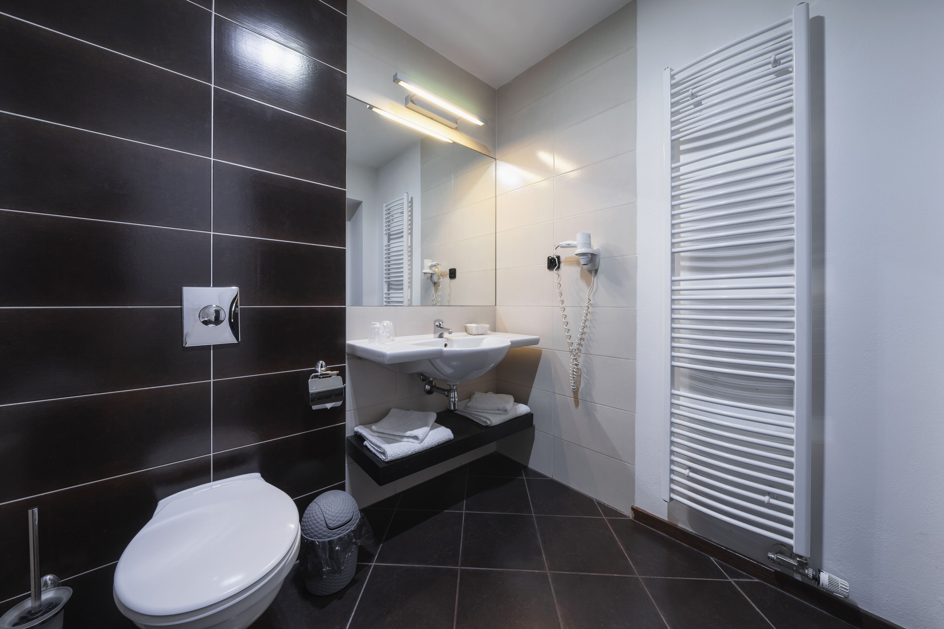 Een moderne badkamer met toilet, wastafel en handdoekhouder.