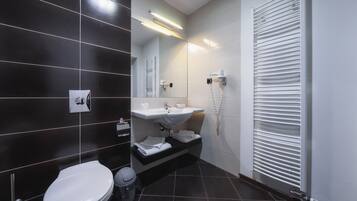 Een moderne badkamer met toilet, wastafel en handdoekhouder.