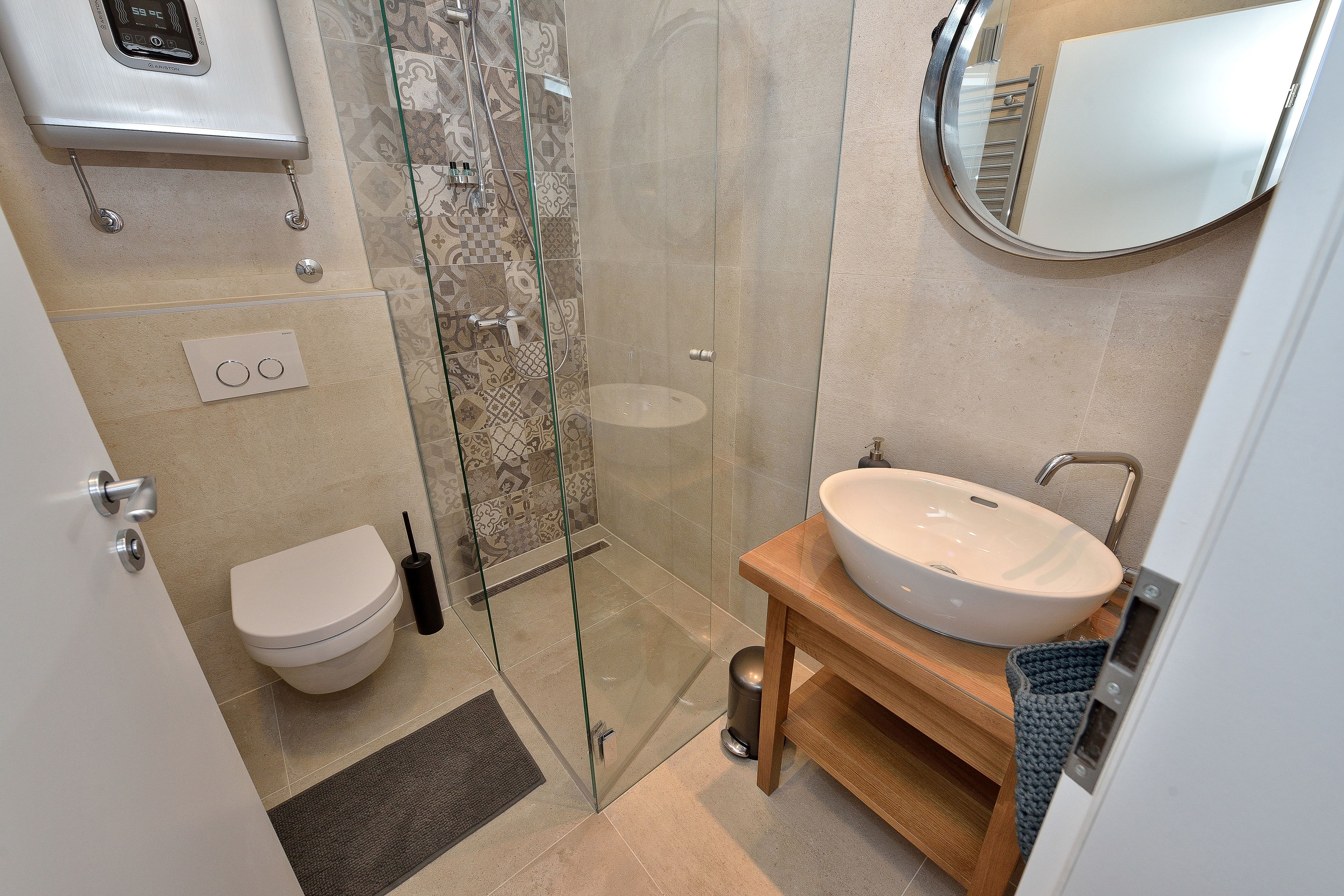 A modern bathroom with a glass-enclosed shower, a white sink, and a toilet.