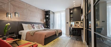 Une chambre moderne avec un grand lit, un bureau et un coin salon.