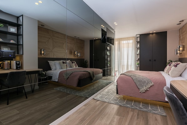 A modern bedroom with a desk, two beds, a TV, and built-in shelving. - Apartments & Rooms Mareta Exclusive (Zadar)