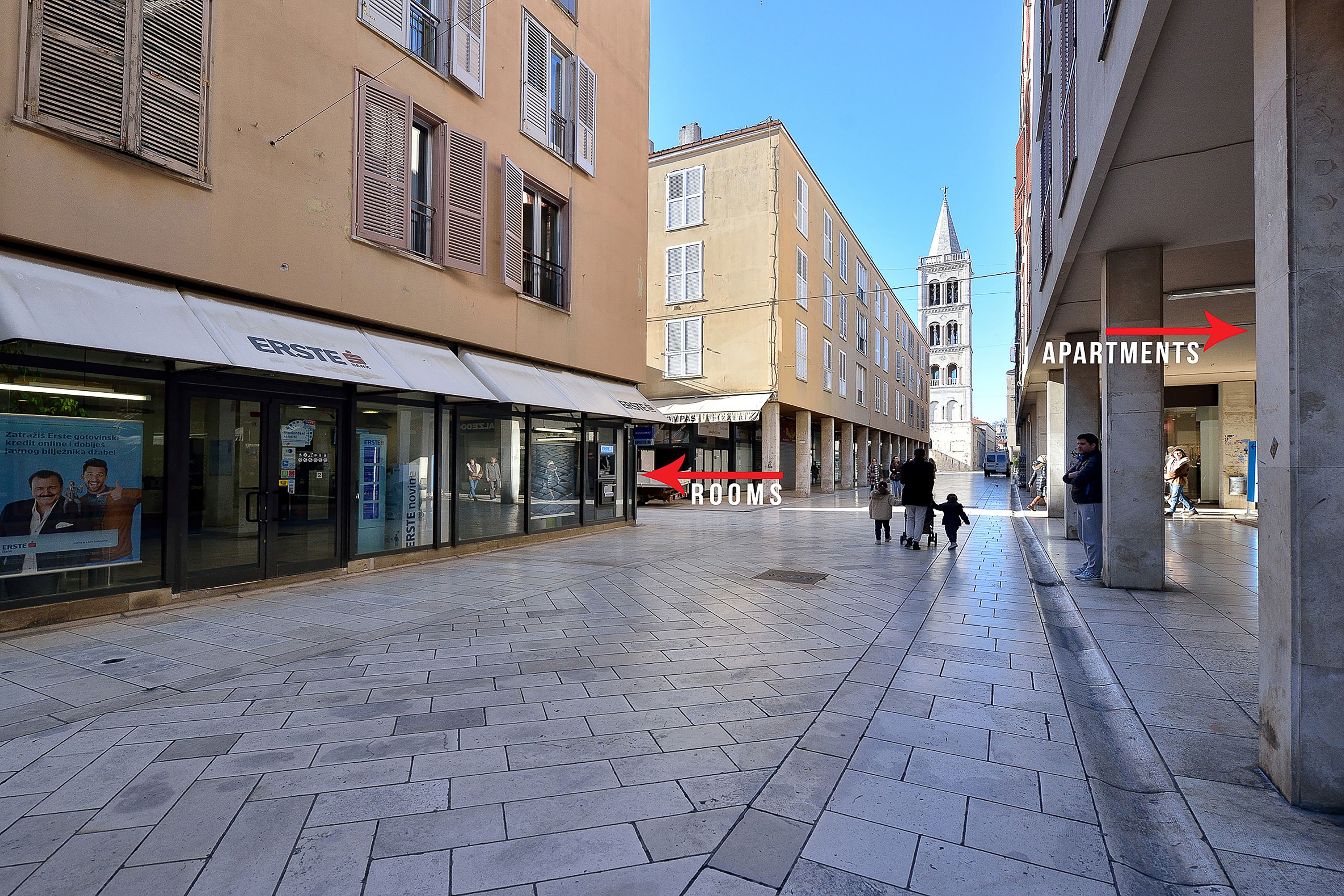 Een voetgangersstraat met winkels en appartementen.