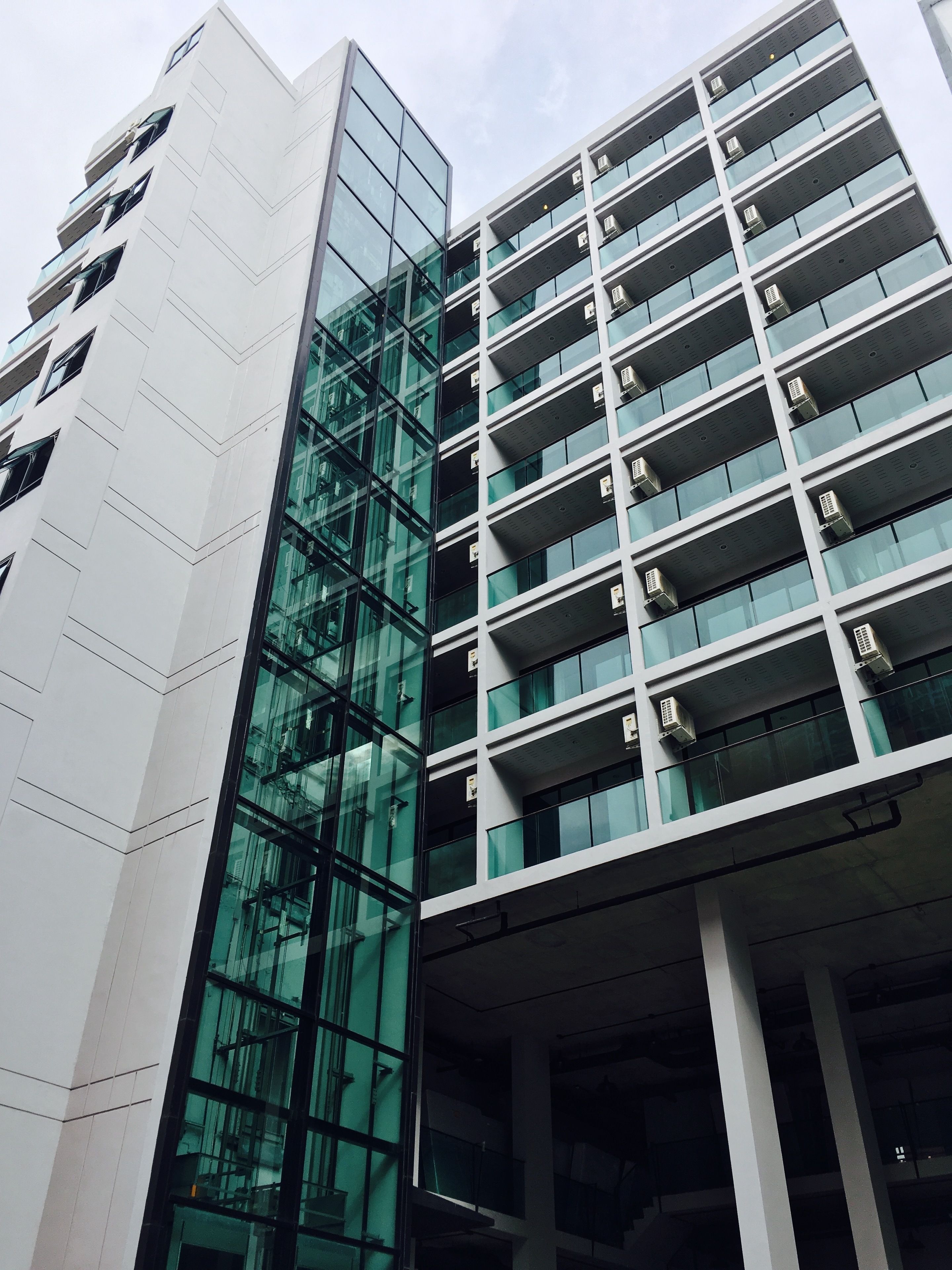 Un edificio moderno con facciata in vetro e diversi balconi.