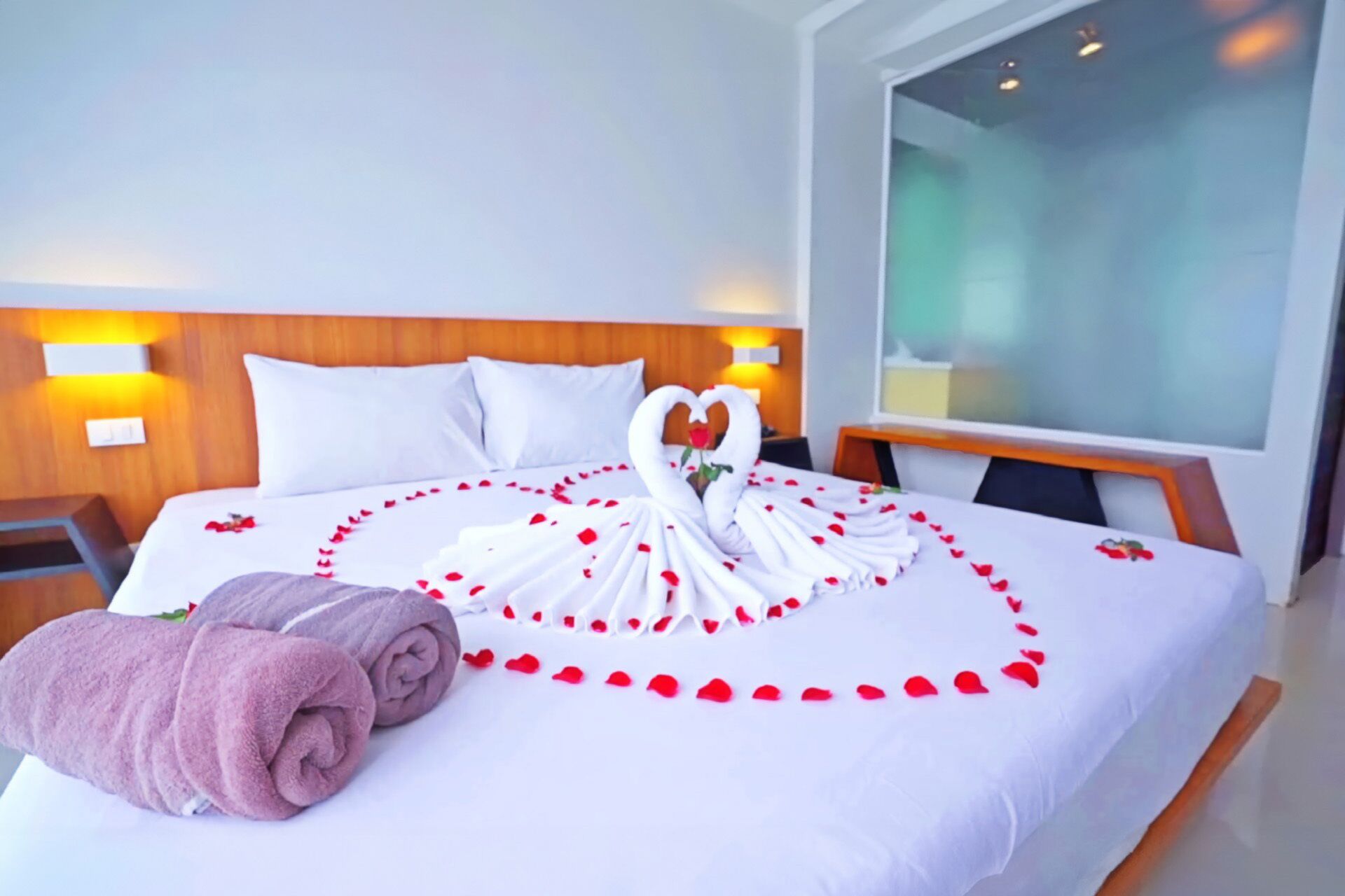 Une chambre d’hôtel avec un lit, une télévision et une tête de lit en bois.
