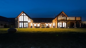 A large, two-story building with a prominent balcony and large windows. - The Steading (Dornoch)