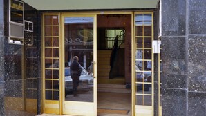 Entrada de hotel con puerta de vidrio, una escalera y un letrero sobre la puerta.
