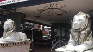 A statue of a lion on a pedestal in an outdoor setting. - Seaview (Pattaya)