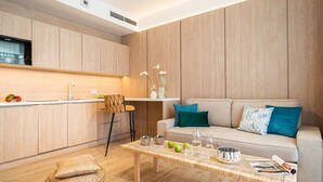 Ein modernes Wohnzimmer mit einer Couch, einem Couchtisch und einer Küchenzeile mit Holzschränken.