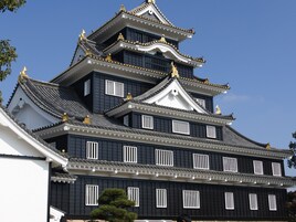 Un castillo japonés tradicional con varios niveles y decoraciones doradas.
