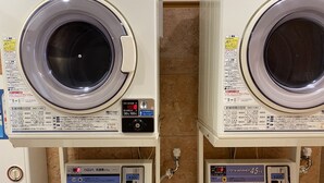 Deux machines à laver à chargement frontal, dotées d’écrans numériques et de panneaux de commande, chacune étant équipée d’un indicateur de niveau d’eau et d’une interface fonctionnant avec des pièces de monnaie.