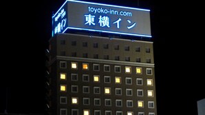 Un hôtel avec une enseigne indiquant « toyoko-inn.com » et « 東横イン » en japonais.