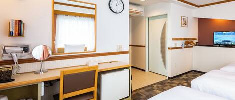 Una habitación de hotel con escritorio, silla, cama, reloj y televisor.