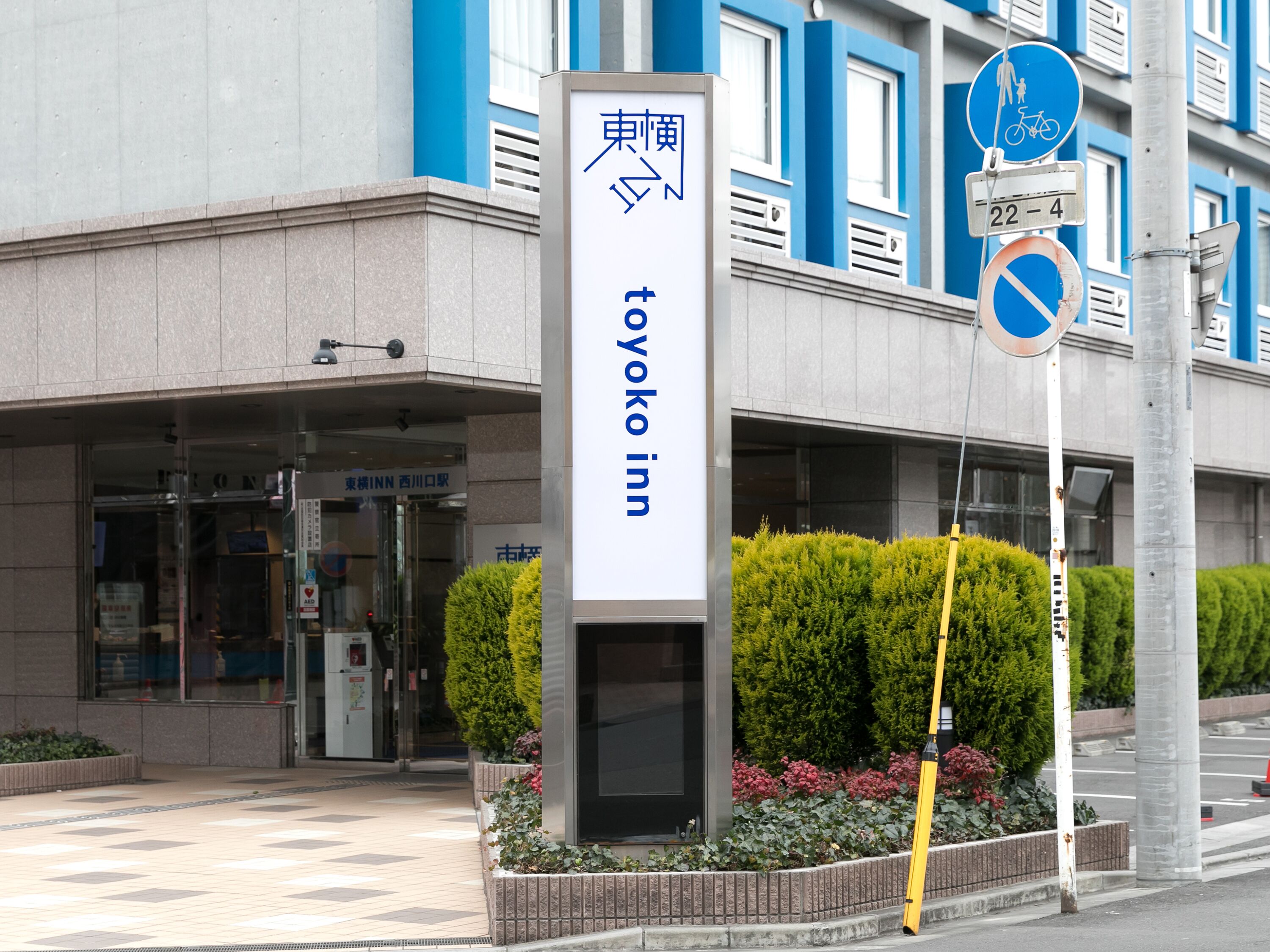 L’entrée d’un hôtel, avec une enseigne indiquant « Toyoko Inn ».