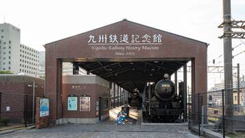 Un museo ferroviario con ingresso coperto, un treno di grandi dimensioni e pannelli informativi.