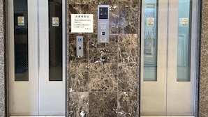 An elevator with marble walls and a sign indicating floor numbers.