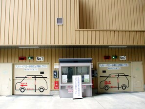 Un bâtiment doté de deux portes de garage, numérotées 1 et 2, chacune affichant un panneau indiquant la hauteur maximale autorisée pour les véhicules.