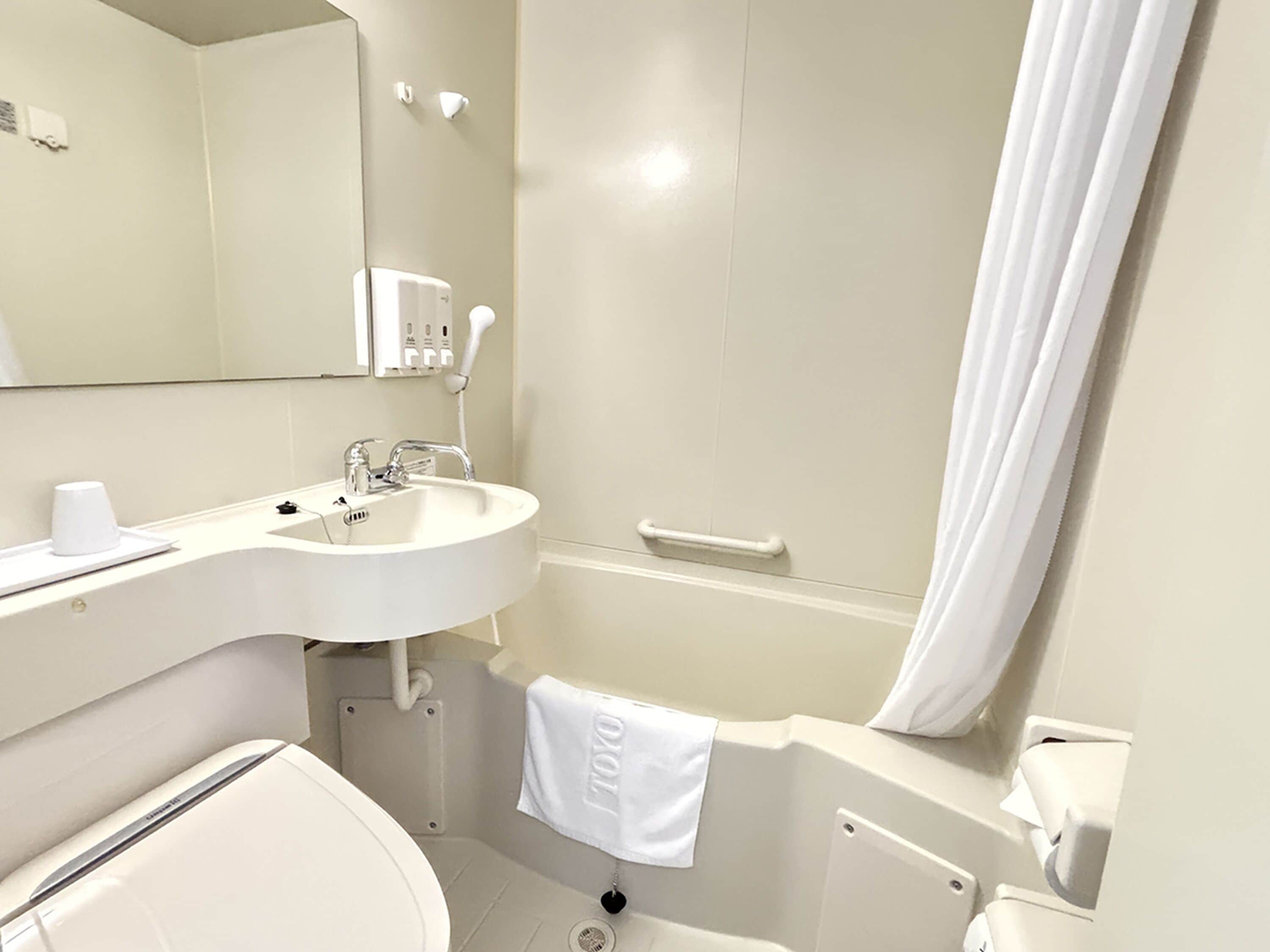 Kombinert dusj/badekar, tøfler, toaletter med elektrisk bidé og håndklær