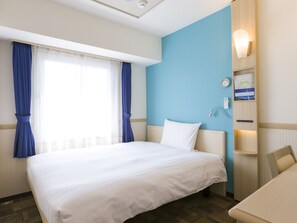 Ein Hotelzimmer mit einem großen Bett, einem Schreibtisch, einem Sessel, einer Wanduhr und einer beleuchteten Wandgestaltung.