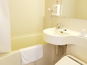 Un baño con lavamanos blanco, un espejo, toallero y ducha de mano.